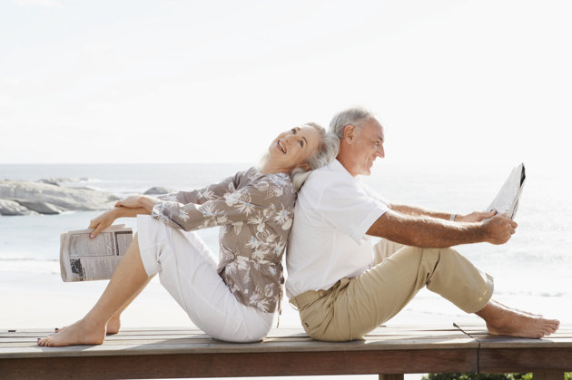 Couple sitting back to back smiling